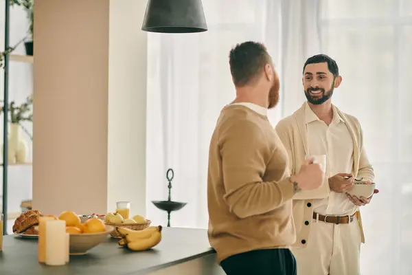 Two men engaged in conversation while standing in a modern kitchen. — Stock Photo