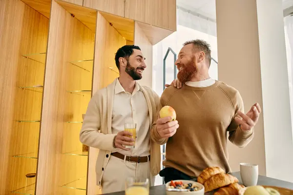 Due uomini felici, una coppia gay, che si godono la colazione in una cucina moderna. — Foto stock