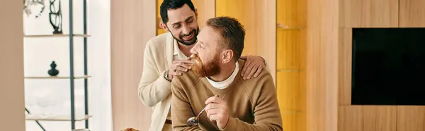 Dos hombres comparten un cálido abrazo en una acogedora sala de estar, irradiando amor y felicidad. - foto de stock