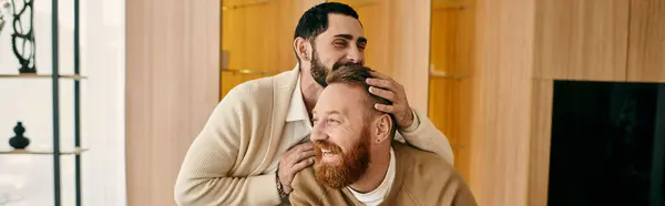Two men embrace tenderly in a cozy home, displaying affection and closeness in their relationship. — Stock Photo
