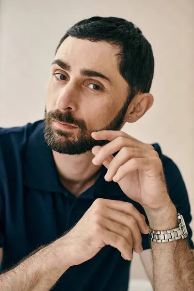A man in a pensive pose, with one hand placed on his chin, showcasing his thoughtful and introspective demeanor. — Stock Photo