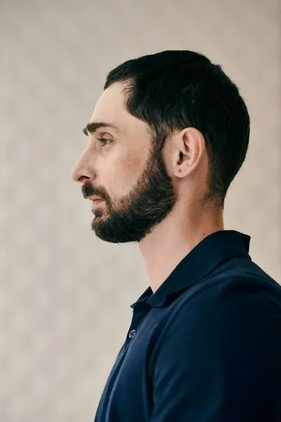 A man with a beard wearing a blue shirt exudes confidence and calmness. — Stock Photo