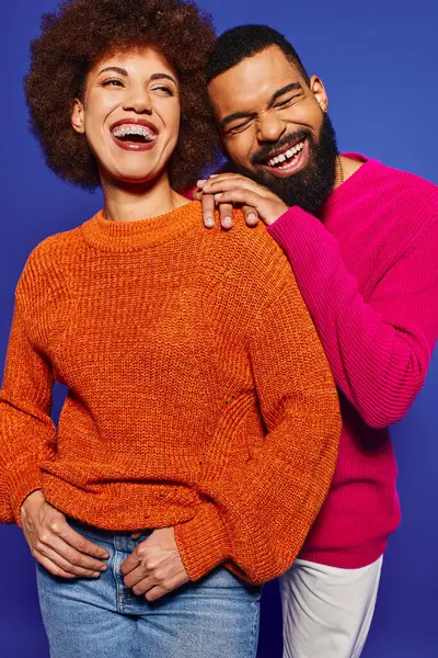 Young African American friends in casual attire strike a pose together, showcasing their friendship on a blue background. — Stock Photo