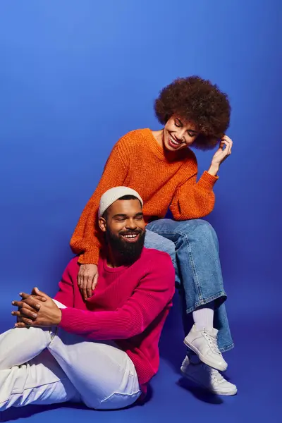 African American friends in vibrant attire sit together, fostering a deep bond amidst the calming blue environment. — Stock Photo