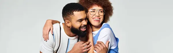 Two stylishly dressed African American friends embracing each other with warmth and affection on a grey background. — Stock Photo
