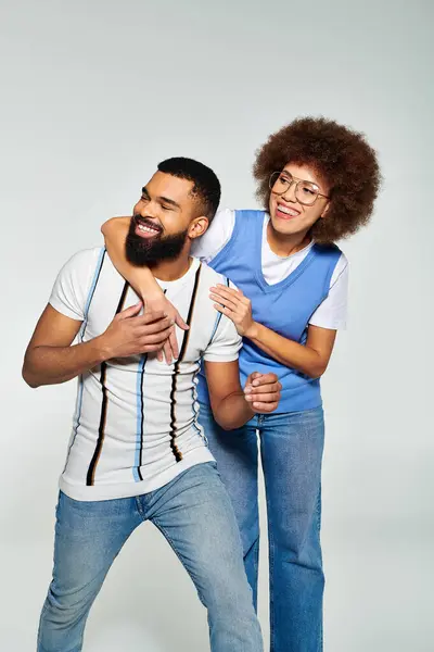 African American man and woman in stylish clothes, posing for a picture on grey background, showcasing their friendship. — Stock Photo