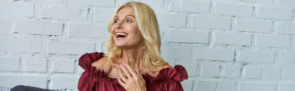 A mature woman in a red top is laughing joyfully. — Stock Photo