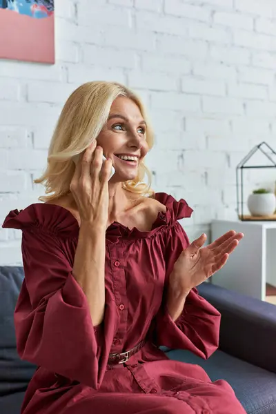 Elegante Frau sitzt auf einer Couch und telefoniert. — Stockfoto