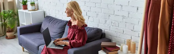 Mujer sofisticada con un atuendo elegante, usando su computadora portátil. - foto de stock