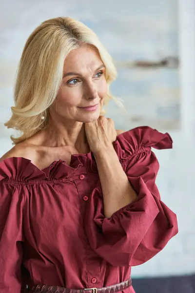 A mature woman in a striking red shirt poses for a photo. — Stock Photo