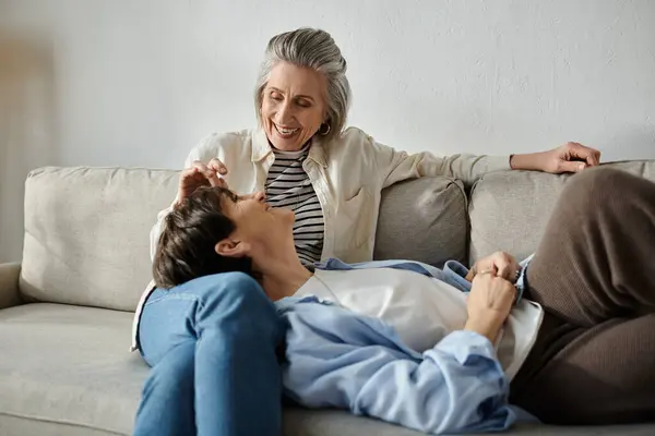 Two women cuddling on a couch. — Stock Photo