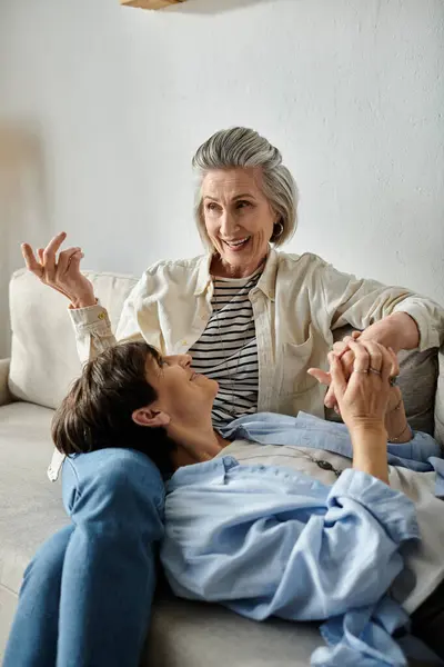 Two women enjoying each others company on a comfortable couch. — Stock Photo