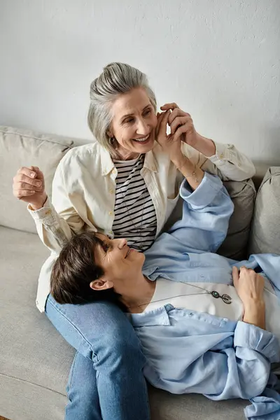 Two women, a loving mature lesbian couple, chatting on a couch. — Stock Photo