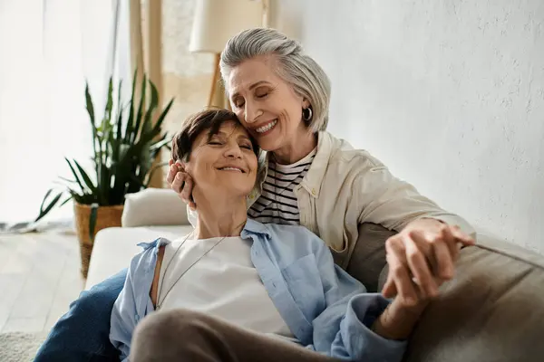 Two sophisticated elderly women relaxing together on a comfortable couch. — Stock Photo