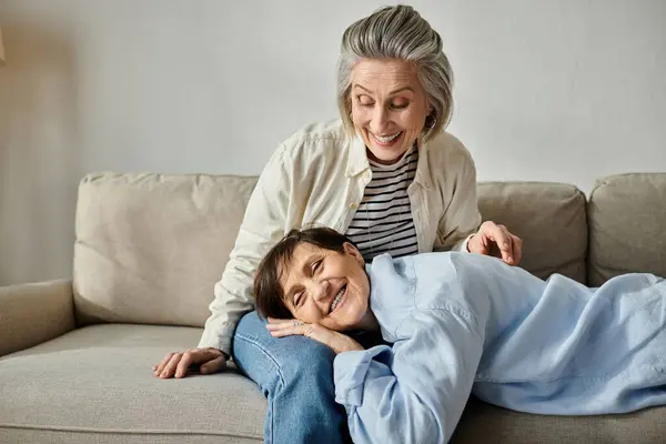 Two women peacefully laying together on a couch. — Stock Photo
