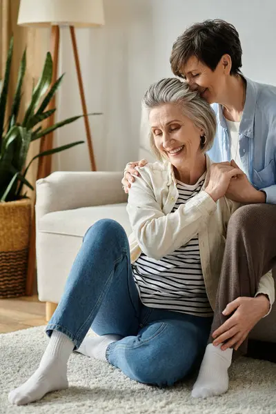 Two elderly women sharing a heartfelt hug on the floor. — Stock Photo