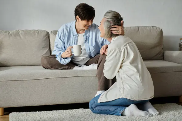 Dos mujeres comprometidas en una discusión sincera en el sofá. - foto de stock