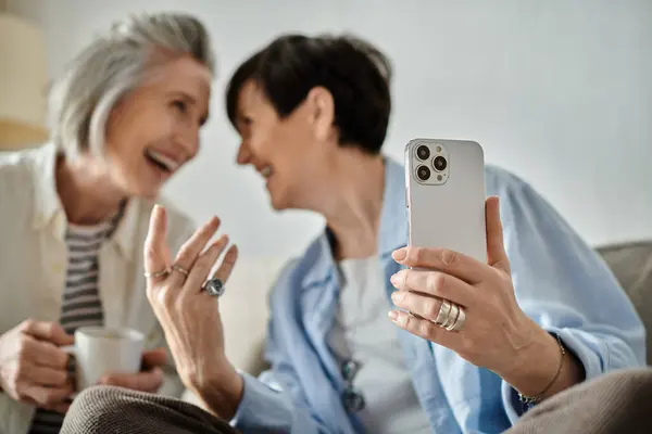 A loving mature lesbian couple posing for selfies with a cellphone. — Stock Photo