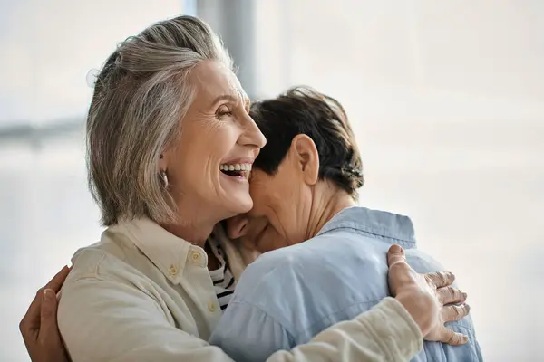 Two mature women, intertwined in a tender hug full of love and comfort. — Stock Photo