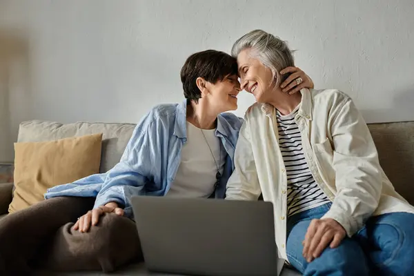 Two elderly women sitting on a couch, using a laptop. — Stock Photo