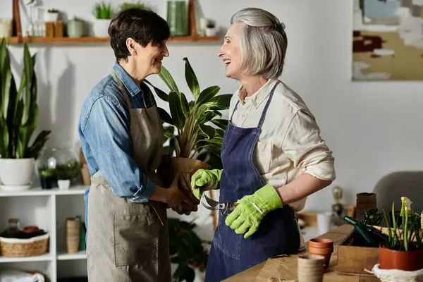 Dos mujeres en una tienda de jardín participan en una conversación privada. - foto de stock