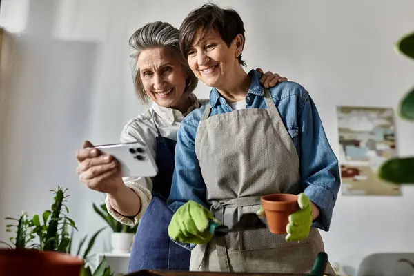 Two women happily photographing their beloved plants together. — Stock Photo