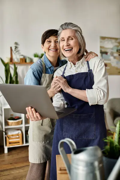 Two women work on laptop in stylish kitchen. — Stock Photo