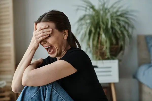 Middle aged woman, experiencing mental breakdown, covers face with hands in distress. — Stock Photo