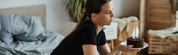 Woman seated with cake on bed — Stock Photo