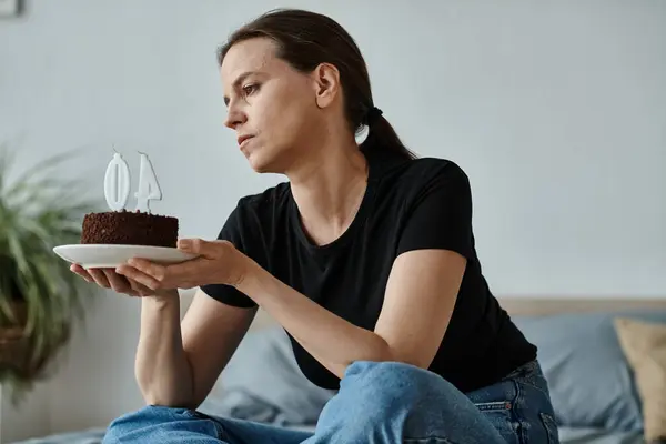 Woman finds solace holding cake on bed. — Stock Photo