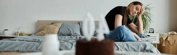 Woman sitting on bed, hands on face — стоковое фото