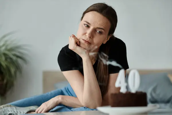 Middle-aged woman sits with cake. — Photo de stock