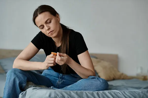 Middle-aged woman sitting on bed, contemplating life. — стокове фото