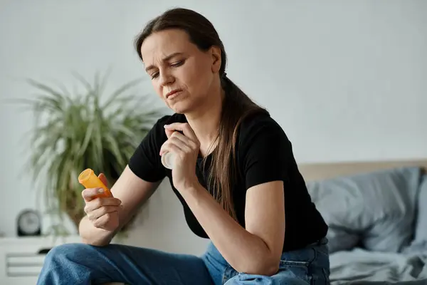 Woman in distress on bed with pills in hand. — Fotografia de Stock