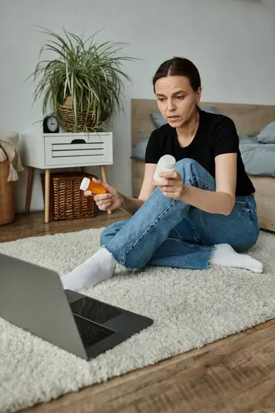 Woman seated with laptop, seeking online support for mental health. — стокове фото