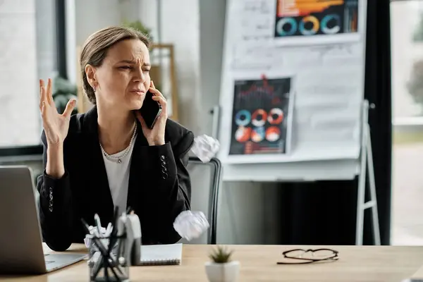 Woman at desk in middle of call, overwhelmed by stress. — Fotografia de Stock