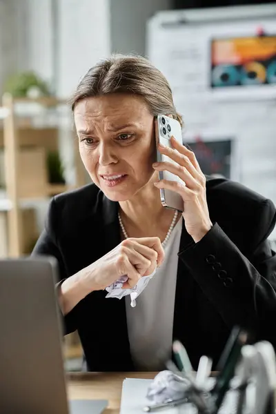 Woman on call, typing on laptop — стокове фото