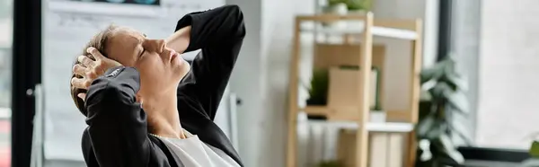 Middle aged woman in business suit stretching in office. — стоковое фото