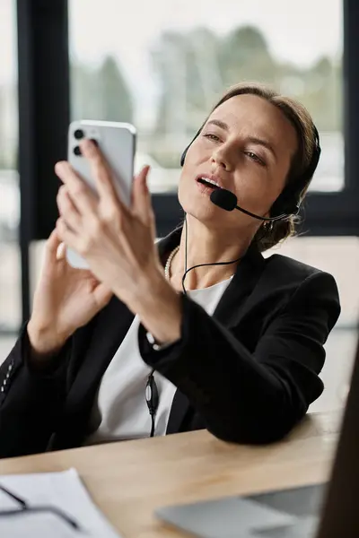 Woman in headset snaps a picture with her phone. — Stock Photo