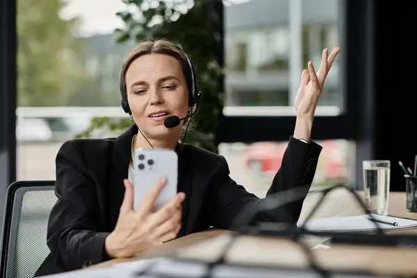 Woman in headset multitasking on phone in office. — Stock Photo