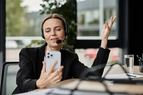 Woman in headset multitasking on phone in office. — стоковое фото