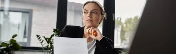 Woman sitting at window, reading paper with intense focus. — стокове фото