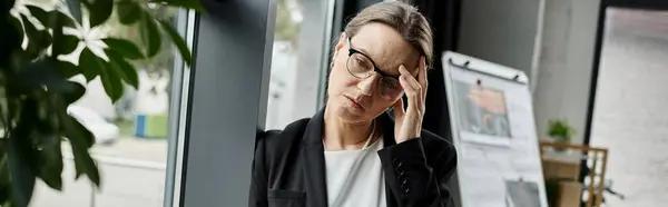 A middle-aged woman holding her head up, stress. — Stock Photo