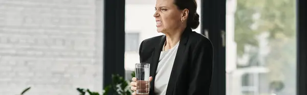 Woman holding glass of water in front of window. — Stock Photo