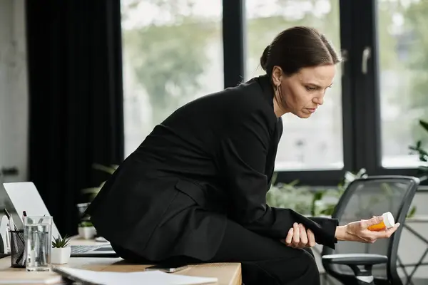 Businesswoman in suit holds a pill in her hand. — стоковое фото