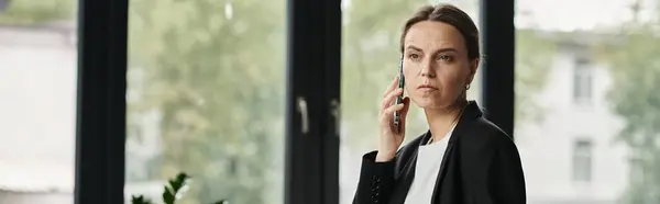 Woman in a moment of contemplation, conversing on phone by window. — Stockfoto