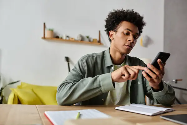 Young man deeply engrossed in digital device while seated at table — Photo de stock