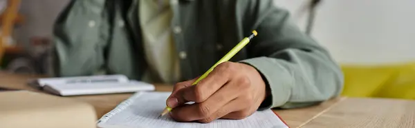 Young man of African American descent engaged in writing in a notebook with a pen. — Stock Photo