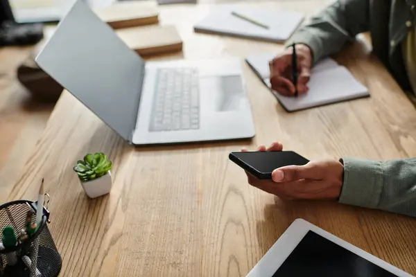 Young African American man at desk with laptop and phone. — Stock Photo