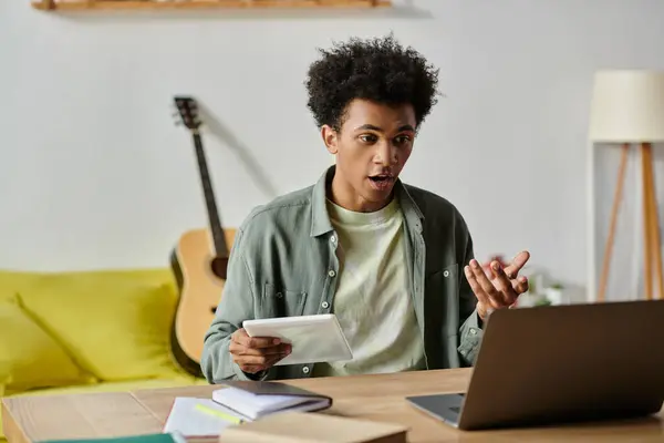 Young African American man studying with a laptop at home. — Stock Photo